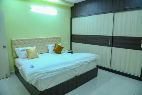 1 dormitorio con 1 cama grande con almohadas amarillas en Leeo Comforts en Visakhapatnam