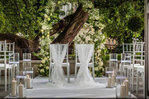 a wedding table with white chairs and candles at Hotel Bellotto in Warsaw