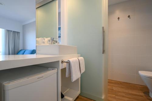 a bathroom with a sink and a mirror at Hotel Pinos Playa in Cala Santanyi