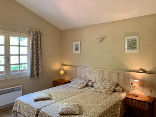 a bedroom with two beds and a window at Villa La casa del gat in Mosset