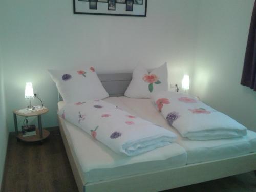 ein kleines Bett mit zwei Kissen darüber in der Unterkunft Apart Silke in Pettneu am Arlberg