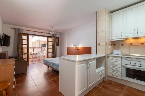 una cucina con mobili bianchi e un soggiorno di GO2TENERIFE Apart'Elisa Near the beach & Pool view a Playa de las Americas