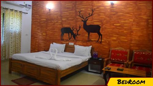1 dormitorio con 1 cama con una pintura en la pared en Kanha Resort, en Kānha
