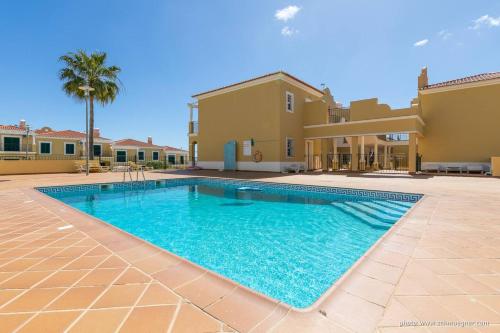 a swimming pool in front of a villa at Casa Brisa do Mar in Porches