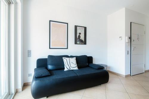 a blue couch sitting in a living room at Prestige Apartments by Quokka 360 - spacious flats with terraces in Lugano