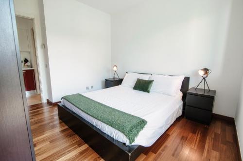 a bedroom with a large white bed with two lamps at Prestige Apartments by Quokka 360 - spacious flats with terraces in Lugano