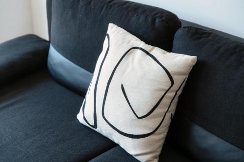a white pillow on a black couch at Prestige Apartments by Quokka 360 - spacious flats with terraces in Lugano