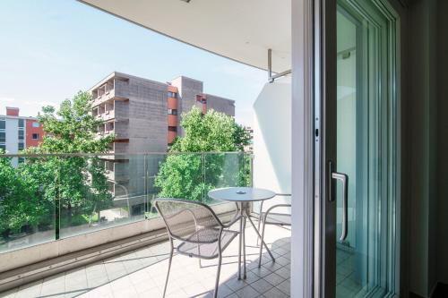 a balcony with a table and chairs and a window at Prestige Apartments by Quokka 360 - spacious flats with terraces in Lugano