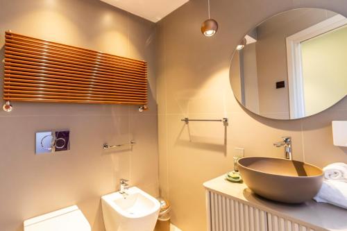 a bathroom with a bowl sink and a mirror at Solmaris Tropea Rooms & Suites in Tropea