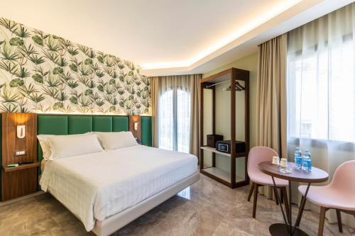 um quarto com uma cama, uma mesa e cadeiras em Solmaris Tropea Rooms & Suites em Tropea