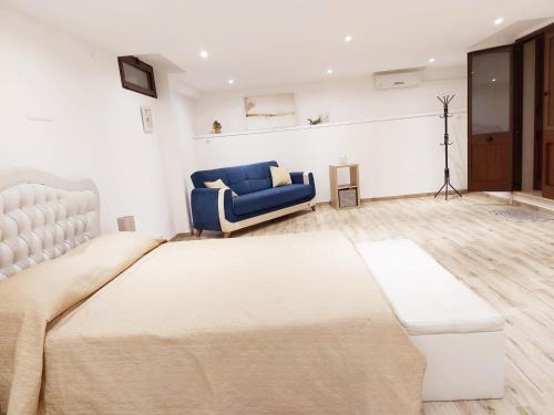 - une chambre avec un grand lit et une chaise bleue dans l'établissement B&B Acchiappasogni, à Corigliano dʼOtranto
