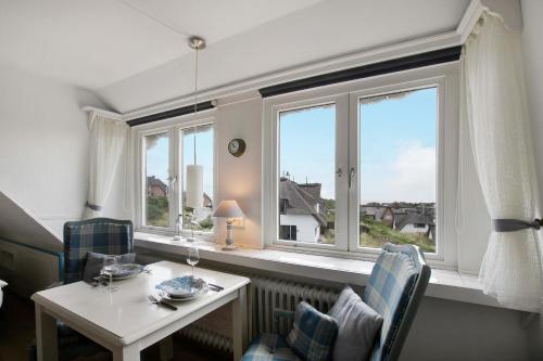 a room with a table and two chairs and windows at Ferienwohnung Haus Lazy Dolphin in Rantum
