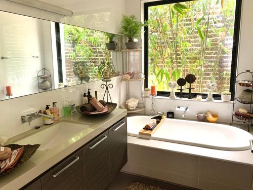 baño con lavabo blanco grande y ventana en Bayside Boutique Retreat- Black Rock, Melbourne. en Black Rock North