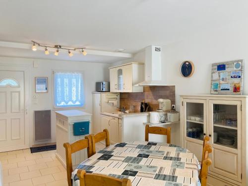 - une cuisine avec une table, une table et des chaises dans l'établissement Maison de l'océan, convivialité et plage à 300m, à Saint-Jean-de-Monts