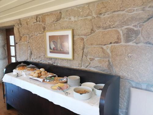 a table with food on top of a stone wall at Quinta da Eira do Sol in Guimarães