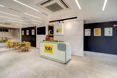 a room with a tv and a table and chairs at FabHotel Prime Oasis Blue in Bhopal