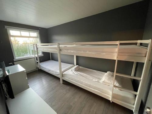 two bunk beds in a room with a window at Lovely Penthouse downtown with 3 bedrooms in Akureyri
