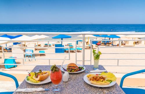 - une table avec deux assiettes de nourriture sur la plage dans l'établissement Akassia Swiss Resort, à Al-Qusair