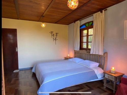 En eller flere senge i et værelse på Casa do Curupira - 3 dormitórios com cozinha e vista incrível perto de Campos do Jordão