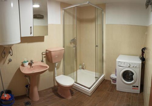 ein Badezimmer mit einer Dusche, einem Waschbecken und einer Waschmaschine in der Unterkunft Old house Djurovic in Herceg-Novi