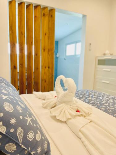 a swan made out of towels on a bed at Maison Marie-Jeanne in Anse Possession