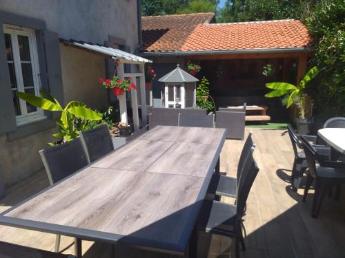 a wooden table and chairs on a patio at Chez Celine et Philippe appartement dans propriété de charme avec piscine in Le Fossat