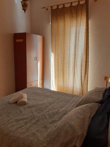 1 dormitorio con 1 cama, nevera y ventana en A Due Passi Dal Centro, en Mazara del Vallo