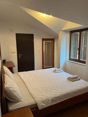 a bedroom with a large bed with two towels on it at Villa Fania in Ohrid
