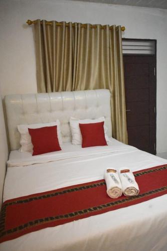 a large white bed with two pairs of slippers on it at Homestay Legundi Syariah in Tanjungkarang