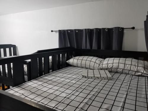 a bed with two pillows on top of it at Casita Mia - Guest House for 9pax with WIFI, NETFLIX, YOUTUBE, KARAOKE, CAN COOK and BBQ in Malolos
