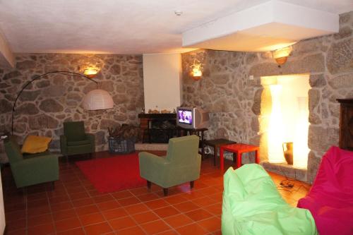 a living room with a couch and a tv at Stone Farm Hostel in Felgueiras