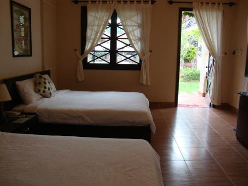 - une chambre avec 2 lits, une fenêtre et une porte dans l'établissement Orchid Boutique Beach Resort, à Phan Thiết