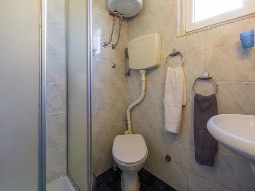 a bathroom with a toilet and a sink and a shower at Apartment KRUNO in Selce