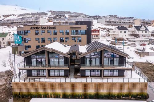 un immeuble avec de la neige au-dessus dans l'établissement Arctic Sea Hotel, à Hammerfest