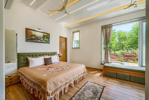 a bedroom with a bed and a large window at SaffronStays Casa De Familia, Karjat - pool villa with ample open space for outdoor games in Jambrung 