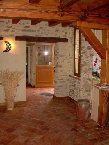 a living room with a stone wall and a door at Le Moulin de Drapras in Chemillé