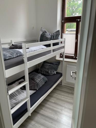 a room with three bunk beds and a window at Fewo Rico 3 in Quedlinburg
