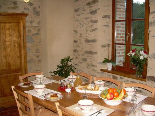 uma mesa de madeira com uma tigela de fruta em Le Moulin de Drapras em Chemillé