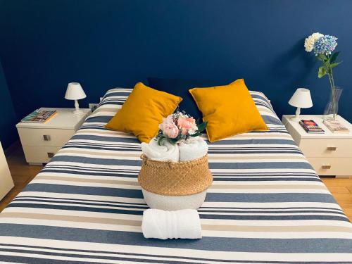 a bed with yellow pillows and a basket of flowers on it at Chiara Guest House - Nuova Metro blu in Milan