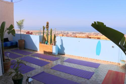 un patio con esterillas de yoga púrpura en un edificio en Azrac Surf Morocco, en Agadir