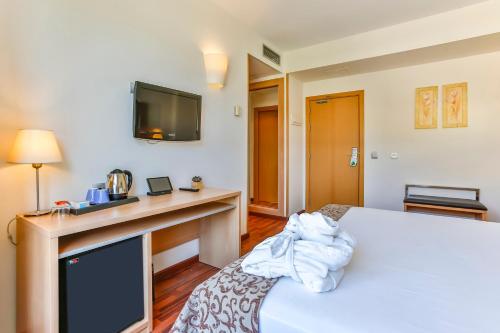 a hotel room with a bed and a tv at Hotel Desitges in Sant Pere de Ribes