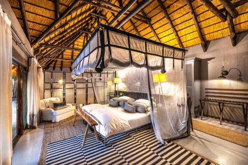 ein Schlafzimmer mit einem Himmelbett in einem Zimmer in der Unterkunft Villa Mushara in Fort Namutoni
