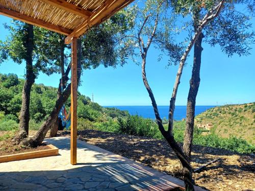 a wooden pergola with a view of the ocean at Agriturismo Le Terre di Veneré in Acciaroli