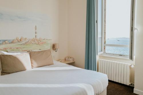 Schlafzimmer mit einem Bett und einem großen Fenster in der Unterkunft Hôtel Aux Tamaris - Vue Mer in Roscoff