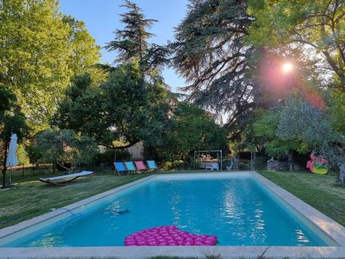 una piscina con un montón de bolas rosas en un patio en 1560- Domaine Des Cinq Jardins- A Magical and Authentic Mansion, en Fuveau