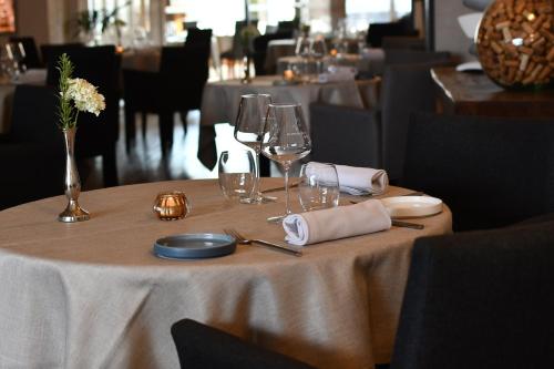 a table with wine glasses and napkins on it at Le Cheval Blanc - Lac du Der - Logis Hotel in Giffaumont