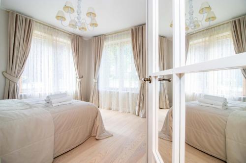1 dormitorio con 2 camas y ventana grande en Seagulls&Dunes APTw/terrace, 2min to the Beach, by Cohost en Klaipėda