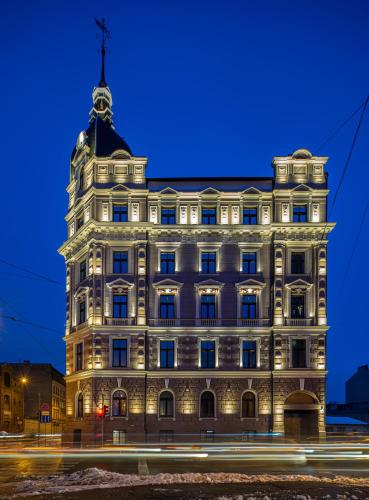a large white building with a clock tower on top at Aparthotel Amella in Rīga