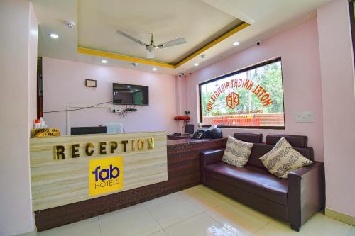 a restaurant with a reception desk and a couch at FabHotel Knight Airways in Guwahati