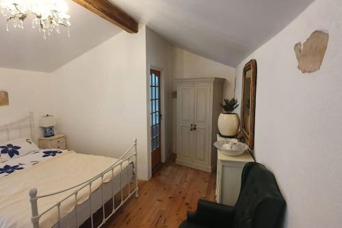 ein Schlafzimmer mit einem Bett und einem Stuhl darin in der Unterkunft Gite Coquille Saint Jacques in Nanteuil-en-Vallée